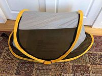 Closed view of the kids tent showing yellow border, black sides and gray top