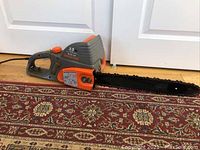 Side view of Remington electric chainsaw showing overall size and handle.