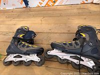 Pair of men's inline rollerblades showing side profile with black, gray, yellow boots on four-wheel silver frames.