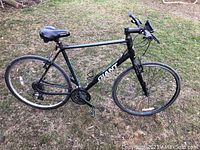 Side view of complete bicycle on grass showing frame, wheels, handlebars and drivetrain