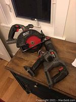 Three Porter-Cable cordless tools on wooden surface near window; circular saw, drill, reciprocating saw; show 18V battery slots without batteries