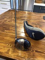 Full view of Nike golf driver with blue and silver head, shaft, and Nike headcover