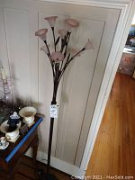 Floor lamp with pink flower-shaped glass shades visible clearly, showing height and design.