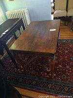 Full view of rectangular oak library table showing carved legs and surface scratches.