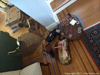 Photo showing brass fireplace screen, fireplace tools, wooden birdcage, and two Sony wireless speaker radios on hardwood floor.