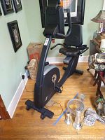 Side angled view of NordicTrack Elite 7.4 recumbent bike showing padded seat, backrest, and digital console at the front.