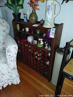 Front view of wooden spice rack leaning against wall with display shelves and cubbyholes