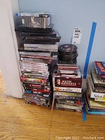 Photo of stacked DVDs and VHS tapes showing various titles including Wallander, Ruth Rendell Mysteries, and other TV series and movies.