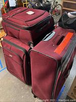 Three burgundy Samsonite soft shell wheeled luggage pieces stacked and shown from above and side displaying condition and general appearance.
