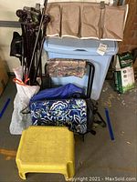 Photo of the lot showing the laundry hamper, foot stool, bags, curtain rods, and camp chair.