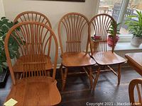 Four oak chairs grouped together showing overall style and finish