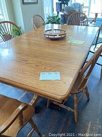 Full view of oak dining table with chairs and round tray on top
