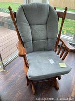 Front view of oak glider chair showing grey cushioned seat and back