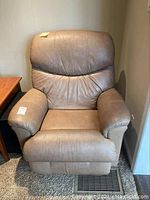 Front view of the tan leather recliner chair, showing overall condition and design