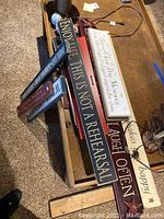 View of various stacked wooden signs with inspirational phrases on a carpeted floor near a table.