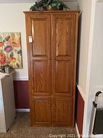 Front view of full oak cabinet showing two-door upper and lower sections