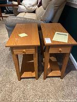 Two solid oak Amish made end tables side by side on carpet next to sofa, showing front and top.