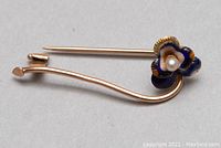 Front view of 10kt gold enamel pin showing blue and orange flower with a cultured pearl center and gold stem