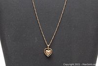 Rope chain and heart pendant displayed on black bust