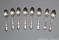 Eight spoons laid side by side showing handles and bowls