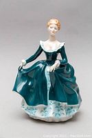 Front view of the Royal Doulton Janine figurine showing detailed facial features, dress, and pose.