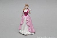 Front view of the Royal Doulton Vicki figurine showing the burgundy bodice and pink and white layered gown.