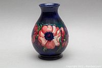 Front view showing red and pink poppies against cobalt blue background