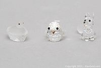 Front view of Swarovski crystal duck, chick, and fox figurines, all clear faceted crystal with black eye details.