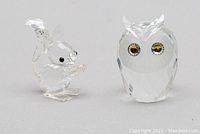 Front view of Swarovski crystal squirrel and owl figurines showing clear faceted crystal and amber eyes on owl.