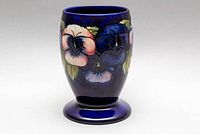 Front view showing tube-lined floral pansy motif on cobalt blue ground