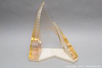 Front angled view showing translucent amber lucite structures and wire details on white base.