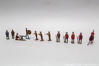 Full view of all ten metal toy soldiers arranged in a line showing variety of poses and uniforms.