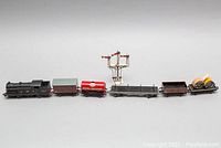 Locomotive, five freight cars and semaphore signal aligned in order