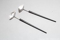 Pair of mid century stainless steel salad tongs with black handles laid flat, showing overall length and design.