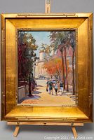 Full view of framed painting on easel against neutral background