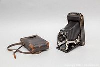Antique Kodak No.1 folding camera shown with accompanying worn leather carrying case.