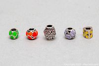 Front view of 5 Pandora 925 ALE silver charms with colorful enamel designs arranged in a row on a neutral surface.