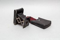 Kodak Vest Pocket Autographic camera partially unfolded shown with black leather case.
