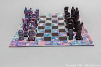 Chess set arranged on the 10x10 board showing all 32 soapstone pieces in two color variations.