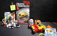 Image showing the full lot of Transformers collectibles including Bumblebee in original sealed packaging, Bot Shots Lockdown in packaging, LEGO Smokescreen set, and assorted articulated figures and vehicles.