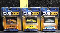 Front view of three sealed Jada Toys DUB CITY die-cast cars, two Ford Expeditions and one Ford F-150, all with trading cards in blister packs