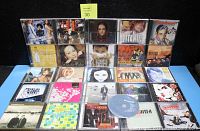 Image showing 23 assorted CDs in jewel cases, some double disc sets visible, varied artists and genres