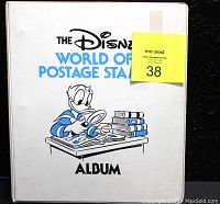 Front cover of white vinyl binder titled The Disney World of Postage Stamps with Donald Duck illustration