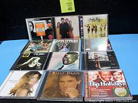 Photo showing 12 assorted CD jewel cases with various artists and albums including Etta James, Sugar Ray, Frank Sinatra, and others.