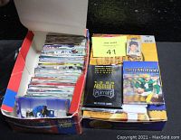 Box filled with loose assorted NFL trading cards and sealed 1995 Absolute Playoff and SkyMotion packs on top.