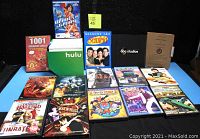 Overview of 19 DVD cases and boxes laid out on blue surface, showing titles and packaging variety