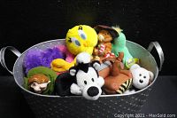 Giant silver textured decorative planter filled with assorted plush toys including Warner Bros Pepe Le Pew, Tweety Bird, and others