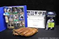 Photo shows the blue binder with 216 assorted 1990 Target basebal trading cards with 2 cards in each sleeved slot, a vintage worn Wilson leather baseball mitt, a congratulatory card for Dodgers, and boxed Chris Taylor Dodgers bobblehead figure.