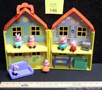 Peppa Pig playset opened showing all included figures and furniture inside the house.