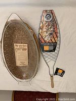 Photo of clear oval glass baking dish with natural woven basket insert alongside fish-shaped wire grilling rack with wooden handle and original tags.